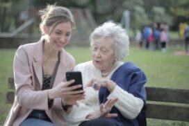 Young lady helps senior to navigate through the online application for Pension Credit