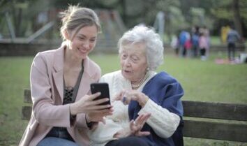 Young lady helps senior to navigate through the online application for Pension Credit